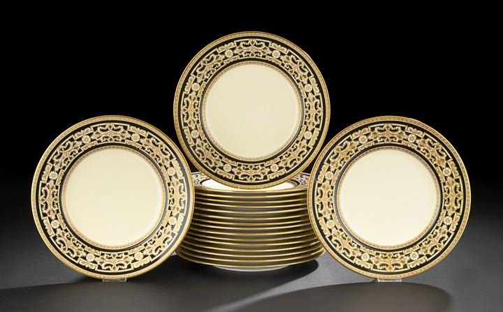 Eighteen Minton Service Plates: Eighteen Minton Service Plates, first quarter 20th century, decorated in rich black-and-gold borders on an ivory background, in the baroque taste, retailed by Rich & Fisher, 411 Fifth Avenue, New York