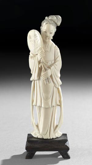 Chinese Carved Ivory Figure of a Maid Attendant: Chinese Carved Ivory Figure of a Maid Attendant, 20th century, the standing figure clad in informal robes with ribboned sashes and holding a fan at the ready, wood stand, h. 7".