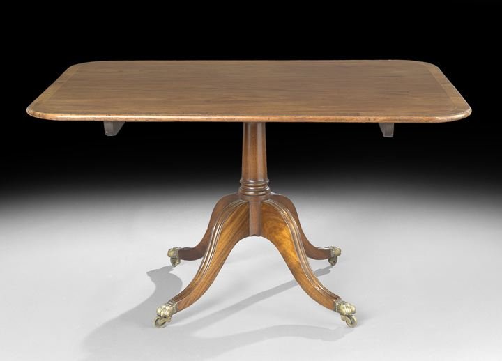 Regency Mahogany Tilt-Top Breakfast Table: Regency Mahogany and Banded Rosewood Tilt-Top Breakfast Table, first quarter 19th century, the rectangular top with rounded corners mounted to a turned standard with four out-curved legs ending in cas