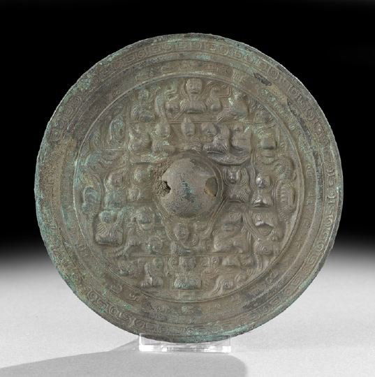 Chinese Cast-Bronze Figural Hand Mirror: Chinese Cast-Bronze Figural Hand Mirror, Han Dynasty (206 BC - 220 AD), of circular outline, cast on the face with a central boss with hole for silk cord, numerous court figures and a border of archai