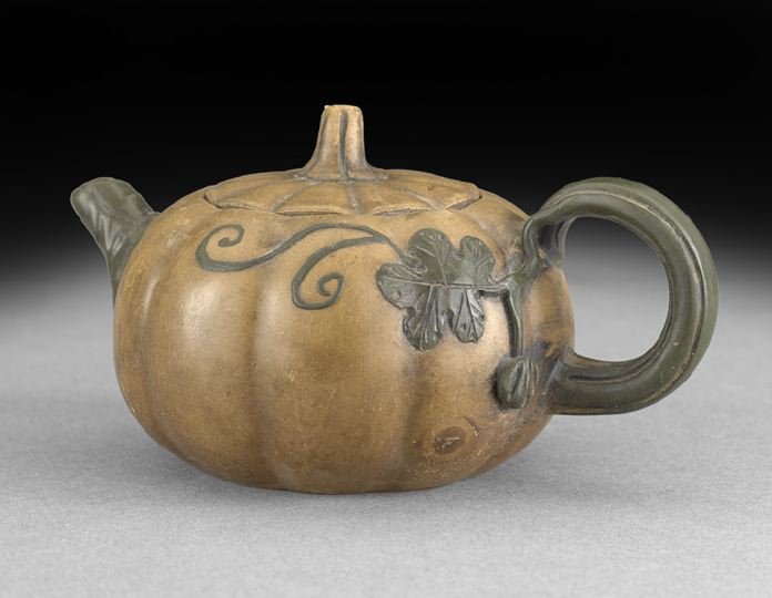Chinese Two-Color Yixing Pottery Teapot: Chinese Two-Color Yixing Pottery Teapot, first half 20th century, potted in the form of a ribbed pumpkin, the body in buff colored clay, the handle, spout and overlay of leaves and tendrils in green c