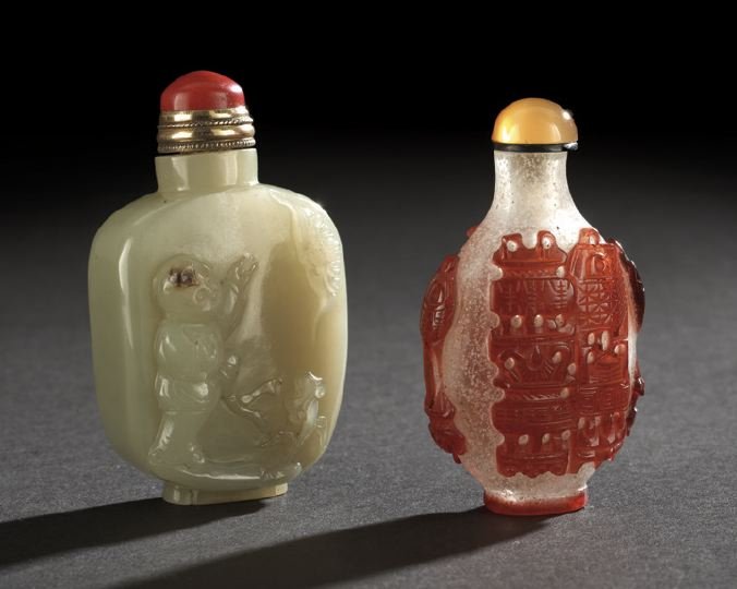 Group of Two Chinese Snuff Bottles: Group of Two Chinese Snuff Bottles, comprised of a celadon-colored jade bottle carved in relief with a boy, a bat and ling chih fungus on the front and a quatrefoil foot rim; the second a red overlay 