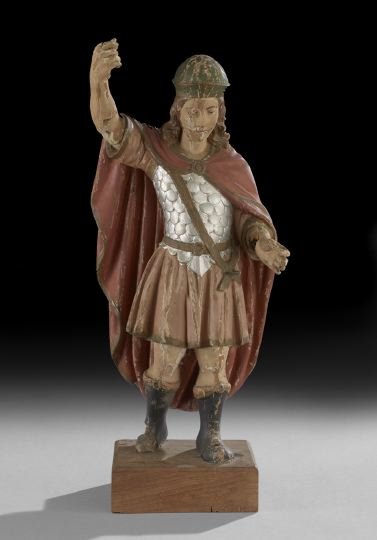 Carved Wooden Figure of St. George: Carved Wooden Figure of St. George, third quarter 19th century, the polychrome figure depicted with downcast eyes, his arm raised to spear the dragon, dressed in a red cape, a green helmet, a flesh-co