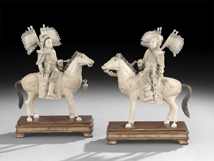 Pair of Chinese Carved Ivory Mounted Figures: Pair of Chinese Carved Ivory Mounted Figures, 20th century, depicting male and female armored Manchu Bannermen mounted on chargers carrying halberds and banners, wooden bases, h. 8".