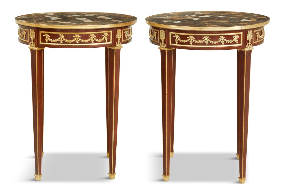 Pair of Louis XVI-Style Marble-Top Center Tables: Pair of Louis XVI-Style Mahogany and Marble-Top Center Tables 20th century, each with a circular marble-top within a brass banding and above a conforming paneled frieze with applied ormolu garlands, r
