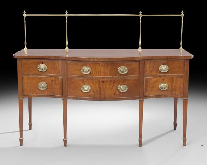 George III Mahogany Sideboard: George III Mahogany Sideboard, early 19th century, the brass and urn-accented rail above a rectangular top with a serpentine front above a conforming case fitted with two central drawers flanked by tw