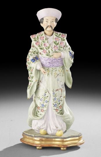 Tinted Parian "Nodder" of a Manderin Figure: Tinted Parian "Nodder" of a Manderin Figure, fourth quarter 19th century, dressed in a pale green gown decorated in the aesthetic manner with cranes, flora and moths, the figure resting on a period gi