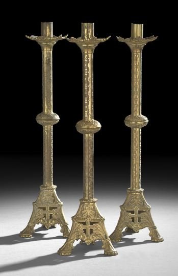 Group of Three Victorian Brass Altar Sticks: Group of Three Victorian Brass Altar Sticks, fourth quarter 19th century, the tripartite bases molded and pierced in the form of crosses terminating in trefoils, the shafts decorated with a chain patt