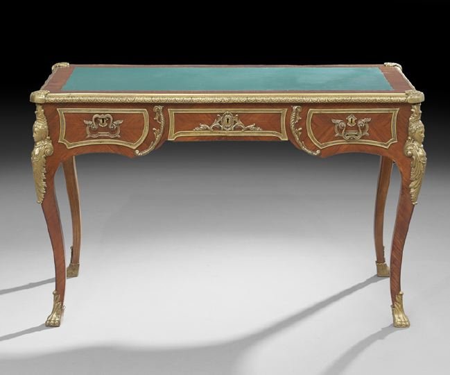 Louis XV-Style Mahogany Bureau Plat: Louis XV-Style Mahogany Bureau Plat, early 20th century, the rectangular top with an inset leather writing surface and within an ormolu banding with corner shield accents, above a frieze fitted with t