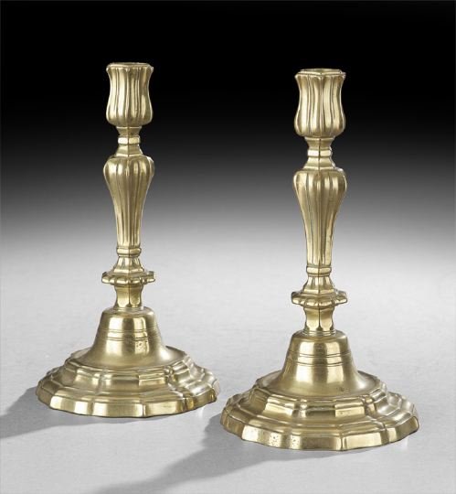 Pair of French Louis XV Brass Candlesticks: Pair of French Louis XV Brass Candlesticks, third quarter 18th century, the domed base stepped and molded in a repeating ogee curve, the vase-shaped standard with alternating ribs and indentations, an