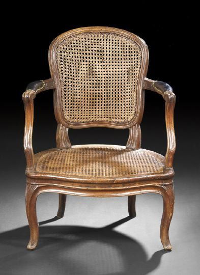 Provincial Louis XV-Style Fruitwood Fauteuil: Provincial Louis XV-Style Fruitwood Fauteuil, early 19th century, the domed and caned back within a molded frame, joined by padded arms to the cushioned caned seat, raised on molded cabriole legs endi