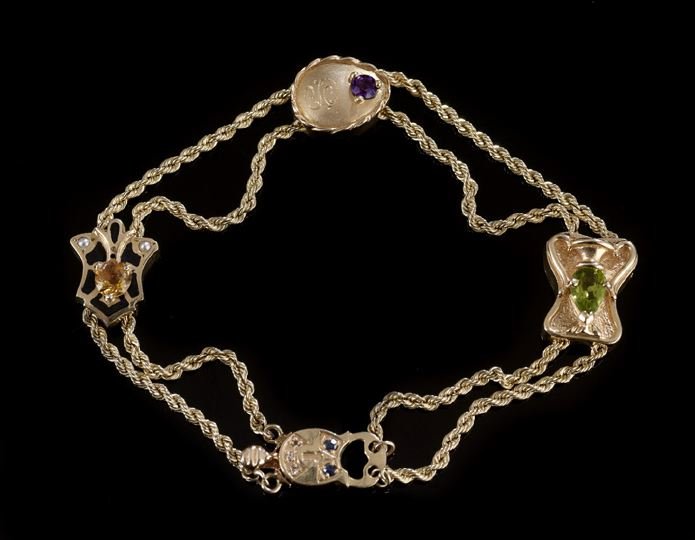 14 Kt. Gold and Gemstone Starter Slide Bracelet: Lady's Fourteen Karat Yellow Gold and Gemstone Starter Slide Bracelet, composed of four slides of various shapes, each set with gemstones, all strung on double-twist link gold chains, l. 8".