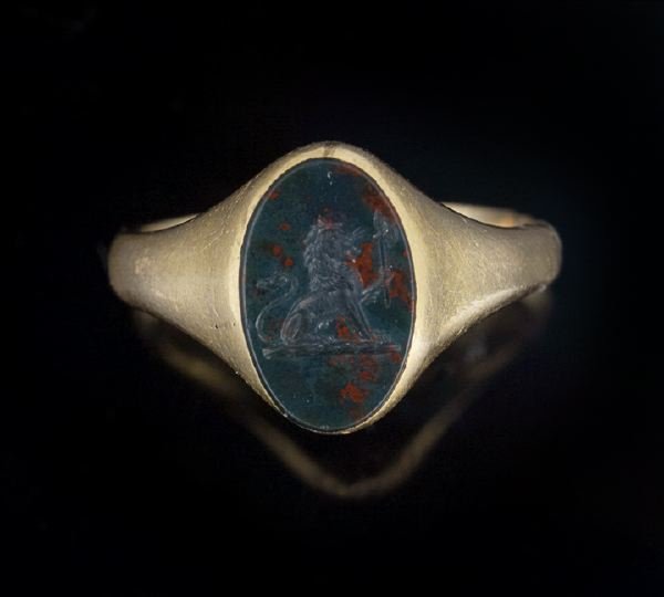 Late Georgian 18 Kt. Gold and Bloodstone Ring: Late Georgian Eighteen Karat Yellow Gold and Bloodstone Intaglio Crest Ring, first quarter 19th century, with an oval bloodstone intaglio engraved with a crest of a lion sejant holding a halberd, beze