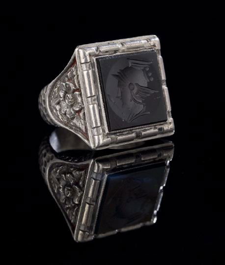 Silver and Onyx Intaglio Ring: Silver and Onyx Arts and Crafts Style Intaglio Ring, with a square onyx intaglio of Athena bezel set in a dentillated surround to a floral-engraved and "hammered" finish shank, size 9.5, 19.5 gr. (inc