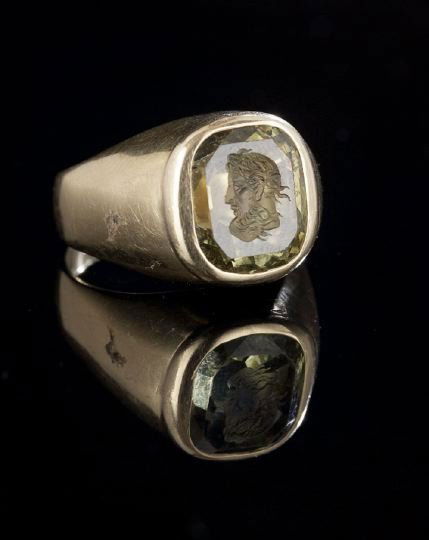 14 Kt. Yellow Gold and Intaglio Green Glass Ring: Fourteen Karat Yellow Gold and Faceted Intaglio Green Glass Ring, with a central cushion-cut green glass imitation peridot, the table engraved with a bust of Poseidon, bezel set in a conforming frame