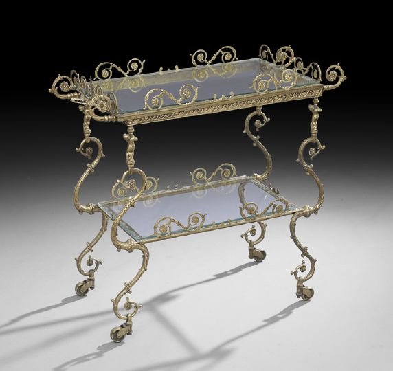 Belle Epoque Brass and Glass Serving Trolley: Belle Epoque Brass and Glass Tiered Serving Trolley, early 20th century, the removable rectangular glass tray top with raised applied scroll sides, joined to a like lower shelf by scrolling supports h