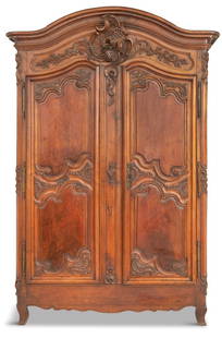 French Provincial Walnut Armoire: French Provincial Walnut Armoire late 18th century, the molded and domed cornice centered by a deeply carved mythical bird, above a case fitted with two long doors, each inset with two shaped panels a