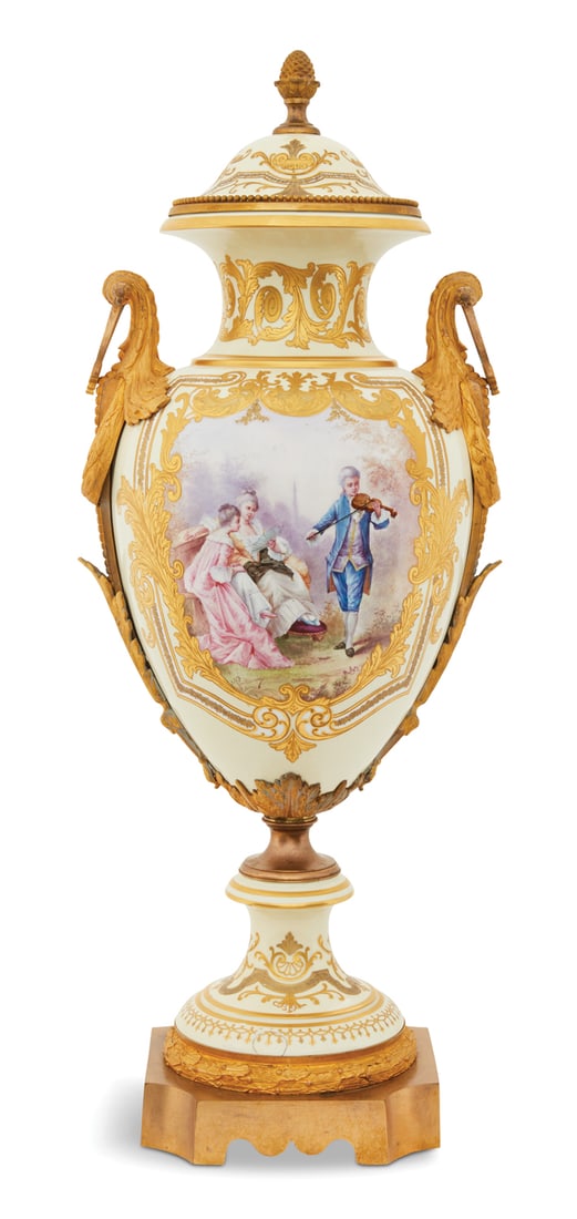French Bronze-Mounted Porcelain Revolving Urn: French Bronze-Mounted Porcelain Revolving Urn ca. 1900, in the Sevres taste, the ogee cover with a pineapple knop, the body with raised gilt scrollwork on a cream-colored ground, the obverse decorated