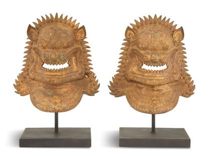 Pair of Thai Guardian Lion Bronze Masks: Pair of Thai Guardian Lion Bronze Masks each growling, menacing lion framed with a mane, the neck decoratively modeled, now mounted on patinated metal bases. h. 21-3/4", w. 17-1/4", d. 7-3/4"