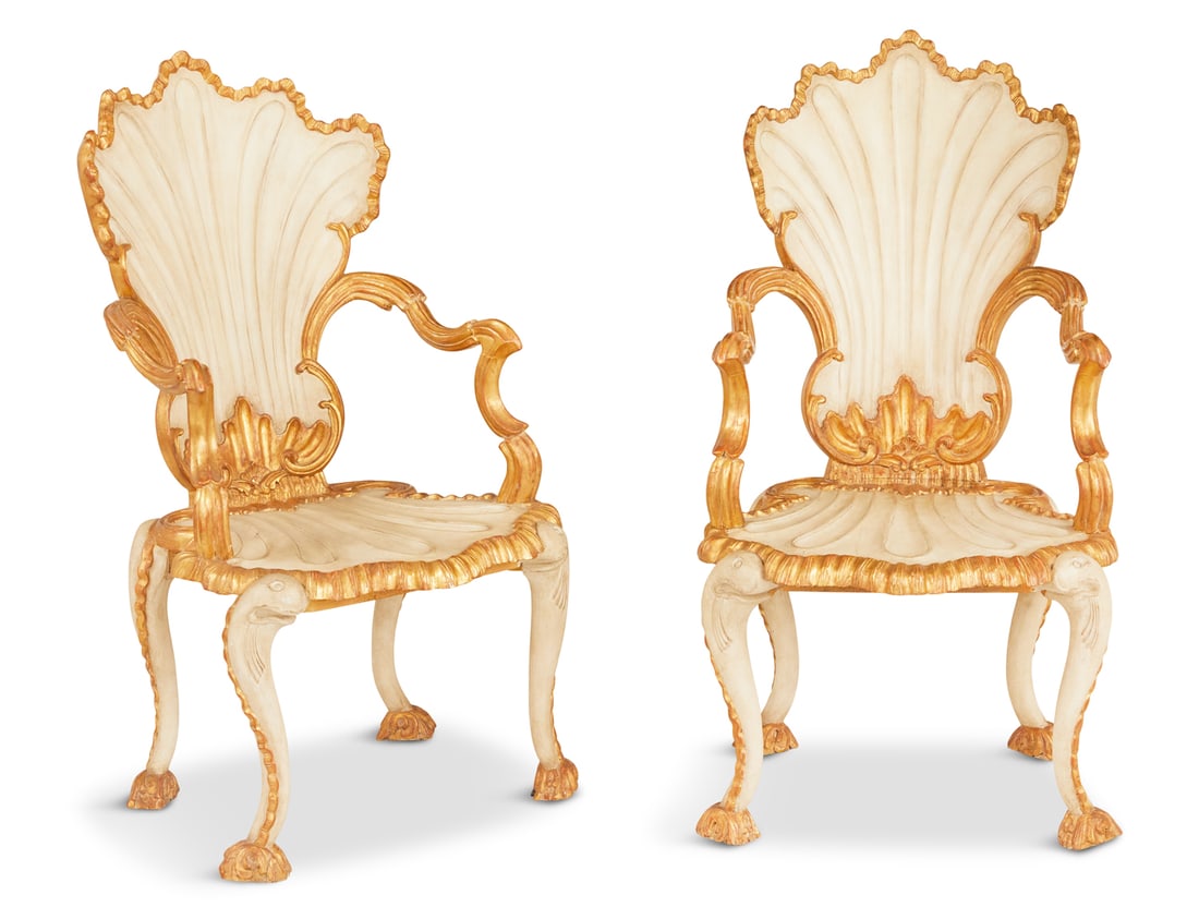 Italian Creme Peinte and Parcel-Gilt Armchairs: Pair of Italian Creme-Peinte and Parcel-Gilt Armchairs in the Grotto taste, the coquiform back joined by molded, exaggerated arms to the like seat, raised on dolphin-form legs ending in foliate-carved