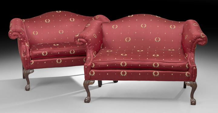 Pair of George III-Style Mahogany Settees: Pair of George III-Style Mahogany Settees, each with a padded domed back joined to the cushioned seat with outscrolled arms, raised on cabriole legs ending in ball-and-claw feet, h. 36", w. 58", d. 30