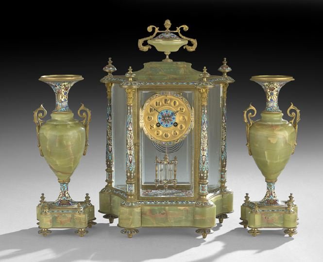 Three-Piece Enamel and Onyx Clock Garniture: Three-Piece French Champleve Enamel and Onyx Clock Garniture, first quarter 20th century, the clock set with an ogee-molded onyx cap supporting an onyx covered cup finial with an enamel lid and scroll