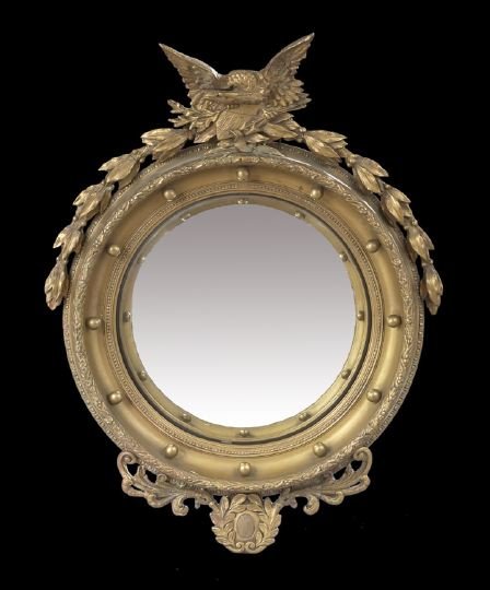 American Classical Revival Giltwood Looking Glass: American Classical Revival Giltwood Convex Looking Glass, early 20th century, the deeply molded frame with twelve balls and featuring an American eagle clenching olive branches, a shield and arrows at