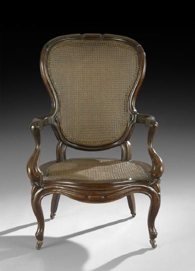 American Rococo Revival Mahogany Armchair: American Rococo Revival Mahogany Armchair, mid-19th century, probably New York, with caned seat and back, of the type manufactured for the Caribbean and Southern markets, the corseted and molded back 