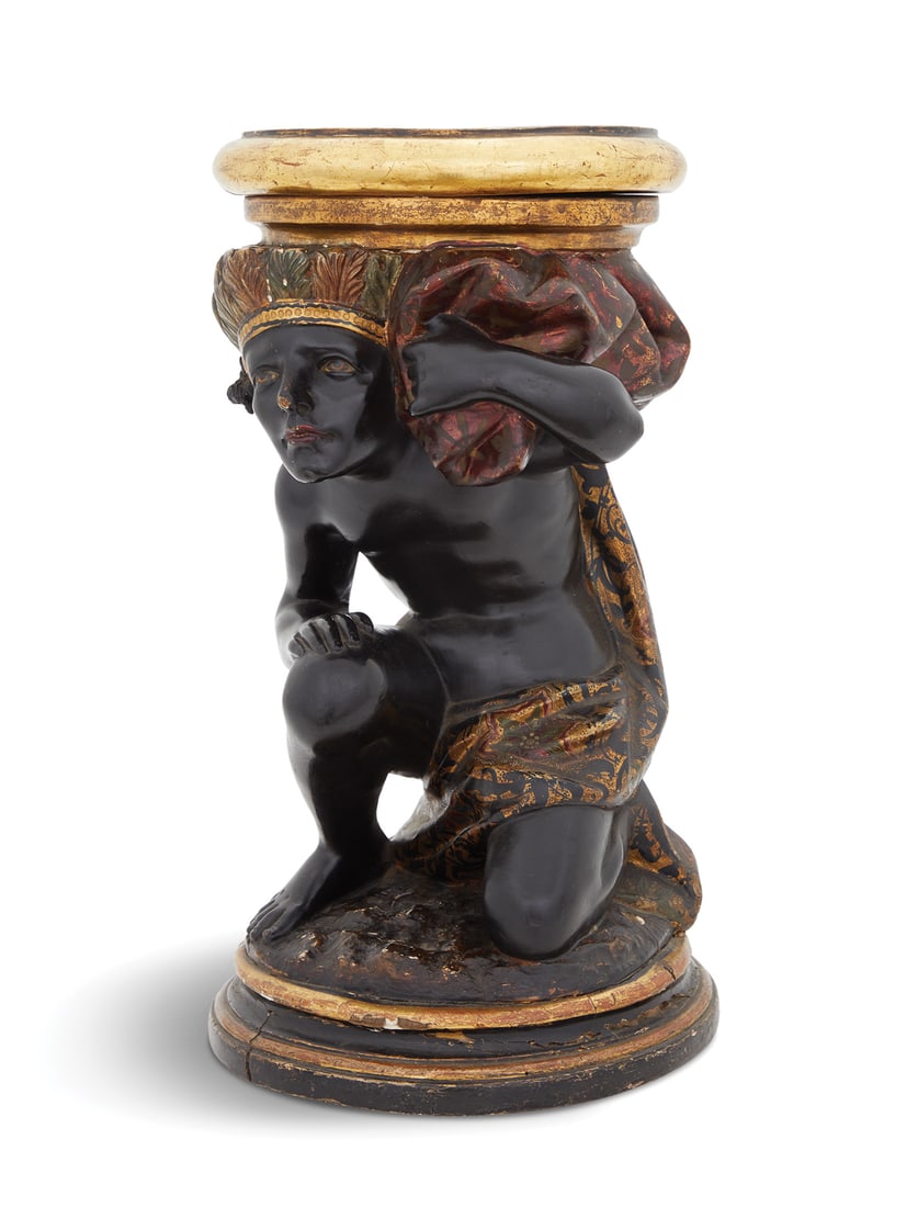 Venetian Carved Blackamoor Pedestal: Venetian Carved Blackamoor Pedestal 19th century, the circular top with a giltwood edge, supported by a crouching figure dressed in elaborate embroidered drapery, on a turned, cove-molded giltwood pli