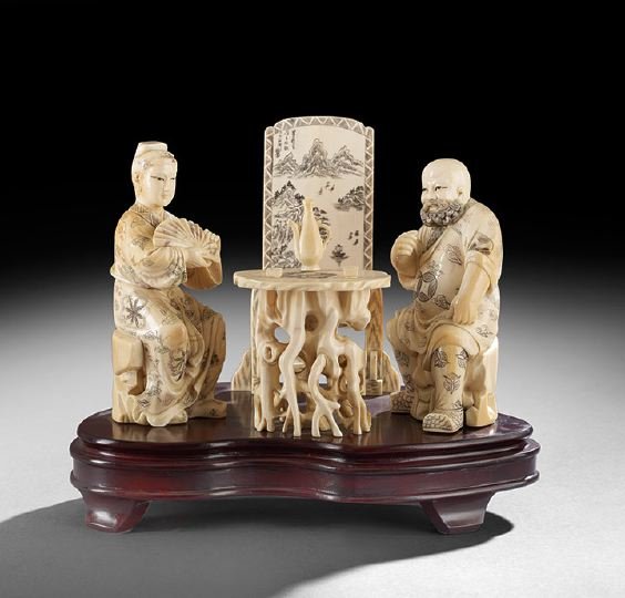 Chinese Carved Ivory Group: Chinese Carved Ivory Group, 20th century, carved with two figures having wine at a rootwood table with a decorative screen at the back, the figures with stained details, fitted wood stand, h. 9-3/4", 