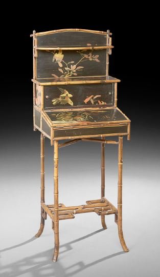 Anglo-Indian Black-Lacquered Writing Stand: Anglo-Indian Bamboo and Black-Lacquered Writing Stand, early 20th century, the domed back above a single narrow shelf and a lower shelf over a pair of sliding cupboards, with a hinged slanted surface 