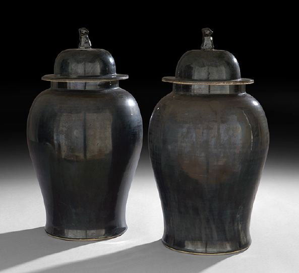 Large Pair of Chinese Export Covered Ginger Jars: Large Pair of Chinese Decorative Export Covered Ginger Jars, each of conventional shape with waisted bodies and conforming domed covers with stylized foo dog finials, glazed all over in a rich black g