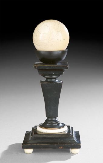 Ivory Billiards Ball on an Ebonized Stand: Ivory Billiards Ball on an Ebonized Stand, 19th century, the ivory bun feet support the ebonized wooden stand, with a square base and tapered standard trimmed with an ivory ring, the cue ball supporte