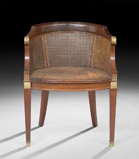 Empire-Style Mahogany Tub Chair: Empire-Style Mahogany Tub Chair, early 20th century, the rounded and paneled crest above double-caned back and sides, the cushioned caned seat raised on paneled tapering square legs headed by ormolu p