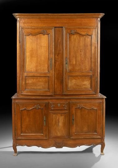 French Provincial Oak Buffet a Deux Corps: French Provincial Oak Buffet a Deux Corps, mid-19th century, the rounded rectangular molded cornice above a case fitted with two doors each inset with two panels, the lower section fitted with a small