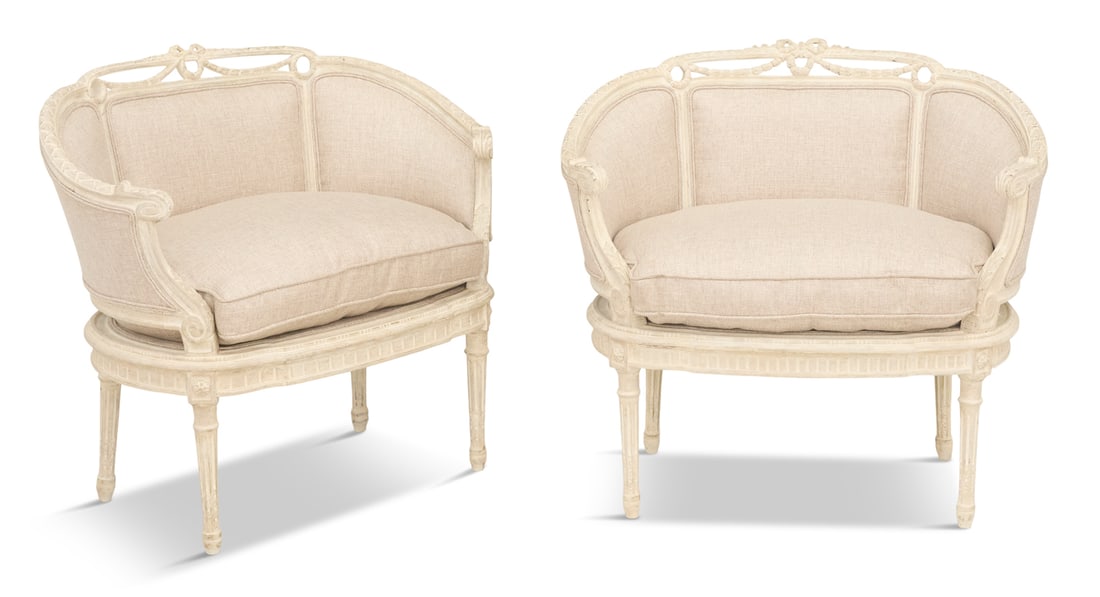 Pair of Louis XVI-Style Boudoir Chairs: Pair of Louis XVI-Style Creme-Peinte Boudoir Chairs 20th century, each with a padded, low back surmounted by a pierced garland and wreath crest, joined by padded, downswept sides to the cushioned seat