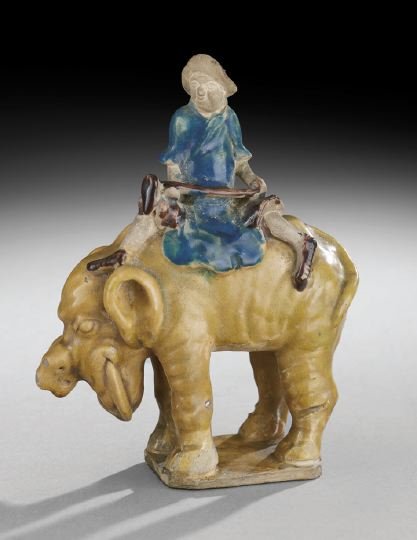 Chinese Pottery Figure: Chinese Pottery Figure, early 20th century, figure seated on the back of an elephant, San Tsai glaze of blue, purple and straw colors, h. 7", l. 5-1/4".