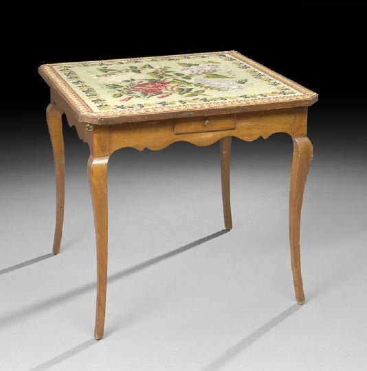 French Provincial Fruitwood Games Table: French Provincial Fruitwood Games Table, late 19th century, the canted square top with an inset floral needlepoint panel, above a scalloped frieze fitted with corner pull-out slides and a small drawer
