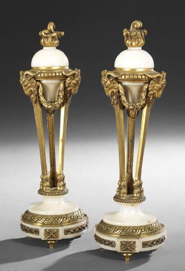 Pair of Louis XVI-Style Garnitures: Pair of Brass and Alabaster Louis XVI-Style Garnitures, early 20th century, each with a circular footed base and the upper section mounted with ram's heads and a central flame, h. 12-1/2".