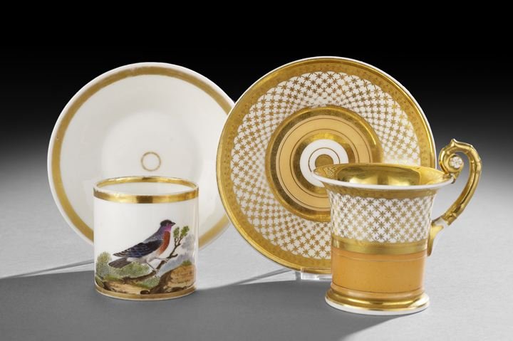 Two Paris Porcelain Cups and Saucers: Two Paris Porcelain Cups and Saucers Attributed to Dante Freres, first quarter 19th century, French, the cup with ornithological decoration depicting a landscape with a ruby-throated black and gray bo