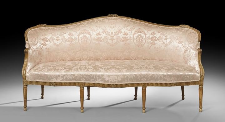 Louis XVI-Style Fruitwood Settee: Louis XVI-Style Fruitwood Settee, late 19th century, the domed and padded back surmounted by a floral crest and within a foliate-carved frame, joined by downswept arms to the like seat, raised above a