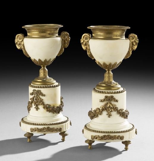 Pair of Bronze and Marble Garniture Urns: Pair of Belle Epoque Bronze and Marble Garniture Urns, ca. 1900, French, turned feet support marble bases decorated with oak leaves and acorns tied in bowknots with a beaded rim, under plinths decorat