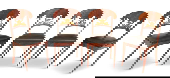 Four Baltic Mahogany Dining Chairs: Four Baltic Mahogany and Parcel-Gilt Dining Chairs each with a highly figured mahogany back crest above stylized carved giltwood dolphins, raised on down-curved legs, the seats covered in black