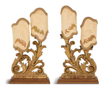 Pair of Italian Giltwood Candelabra: Pair of Italian Giltwood Candelabra 19th century, now mounted as lamps, the baroque-style candelabra with fluted tole drip pans mounted on pierced acanthus-carved bodies with rocaille trim, fitted