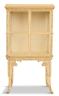 Italian Creme-Peinte Vitrine: Italian Creme-Peinte Vitrineca. 1900, in the Baroque taste, with a molded and carved protruding cornice over a four-square glazed front, one end with an access door, raised on carved legs ending in fl