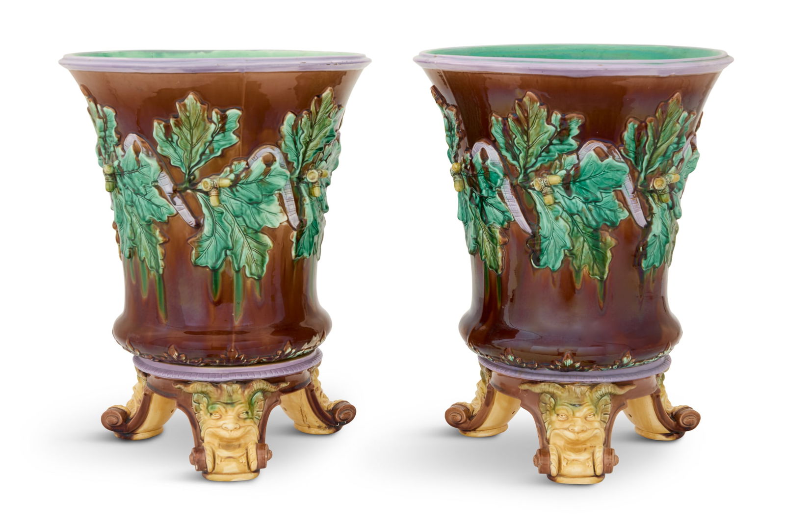 Pair of Imposing Majolica Jardinieres on Stands: Pair of Imposing Majolica Jardinieres on Standslate 19th century, the flaring bodies decorated with oak leaves and acorns on a brown ground, the mauve-trimmed bases with scrolled feet molded with saty