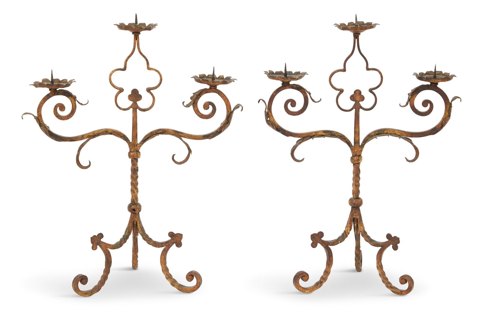 Pair of Gilt-Metal Candelabra: Pair of Gilt-Metal Candelabra in the Baronial Tastelate 19th century, each with three pricket candle holders on floriform drip pans mounted on leaf-decorated and scrolled branches, the rope-twist stan