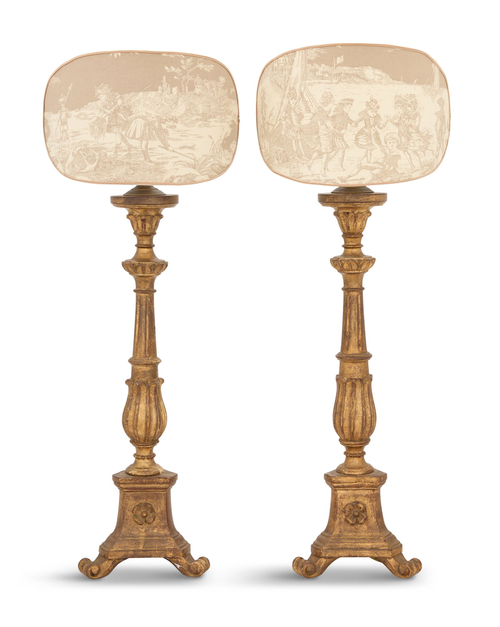 Pair of Giltwood Altar Stick Lamps: Pair of Giltwood Altar Stick Lamps20th century, the column-form standards carved with lotus leaves and fluting, on tripartite bases carved with floriform medallions and raised on scrolled feet, fitted