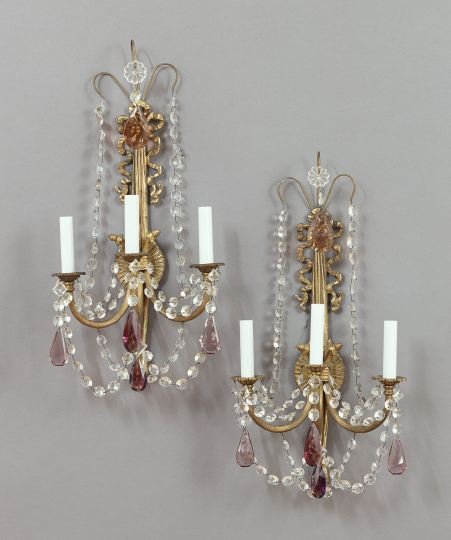 Pair of Continental Polished Bronze Wall Sconces: Pair of Continental Polished Bronze Three-Light Wall Sconces, in the neoclassical style, the ribbed arms supported on bowknot and tassel-back plates and hung with festoons of clear and mauve prisms, h