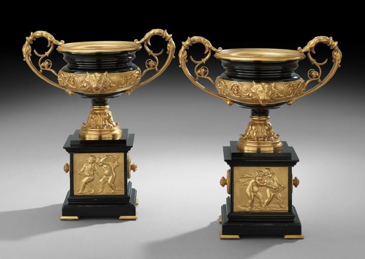 Pair of Napoleon III Black Marble Garniture Urns: Pair of Napoleon III Black Marble and Gilt-Bronze Garniture Urns, third quarter 19th century, each crater-form urn with a bronze plaque on its base, one depicting fall with a pair of putti harvesting 